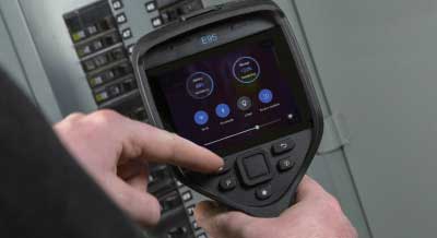 An individual using a FLIR EXX thermal imaging camera's streamline reporting features.