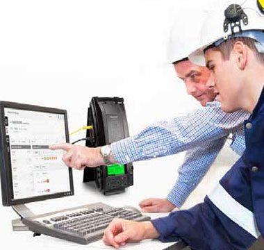Two workers looking at computer, and IntelliDox is beside it